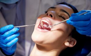 doctor in blue gloves checking a patients mouth