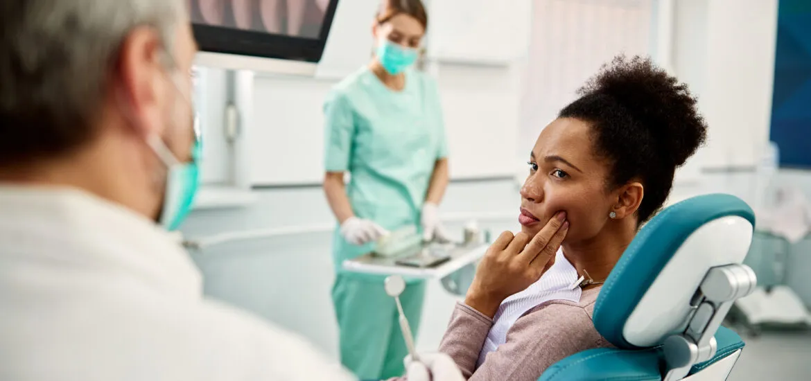 woman talking to a dentist and complaining about pain in her teeth, modern dental office
