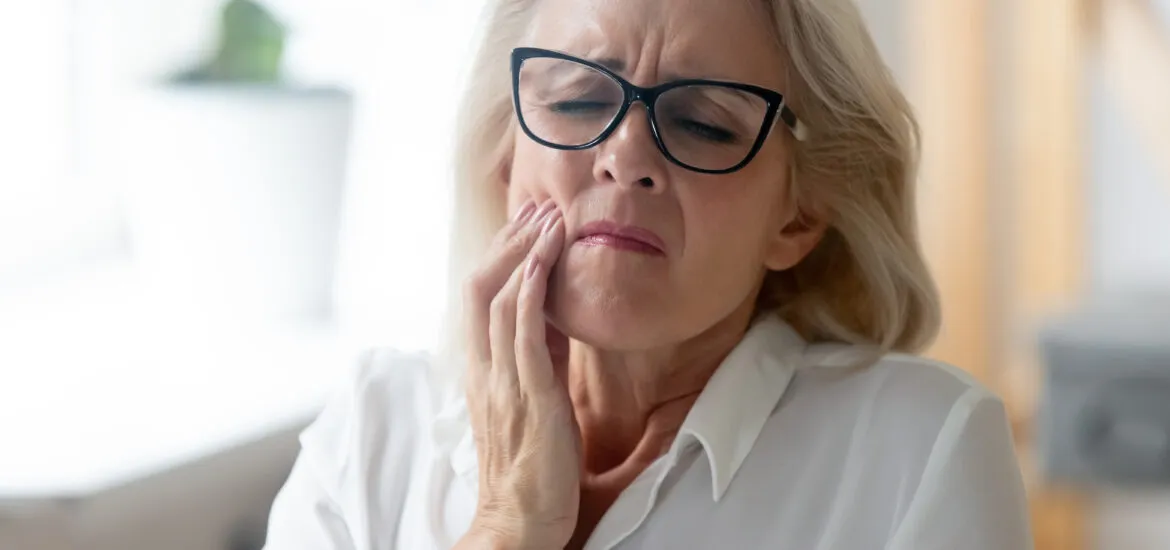 older woman suffering from severe tooth pain